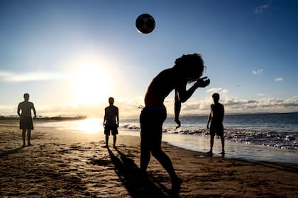 Australia, Byron Bay: los bañistas juegan con una pelota en una playa en Byron Bay a medida que las restricciones de coronavirus se están suavizando lentamente en Australia con estados y territorios en diferentes etapas en el mapa de ruta para reabrir la nación.