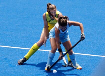 Sofía Toccalino protege la bocha delante de Karri Sommerville, en el Argentina vs. Australia de hockey sobre césped en el mediodía japonés del sábado en los Juegos Olímpicos de Tokio.