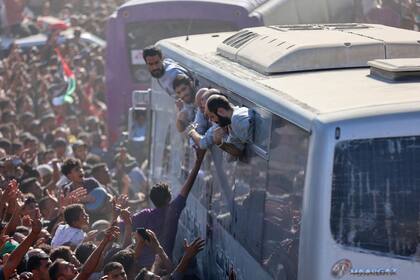 Autobuses que transportan palestinos liberados de las cárceles israelíes en virtud de un acuerdo de alto el fuego e intercambio de rehenes en Gaza con facciones palestinas, llegan al hospital Nasser en Khan Yunis, en el sur de la Franja de Gaza, el 13 de octubre de 2025