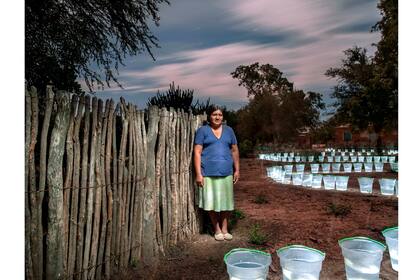 Avelina Torres, integrante de la comunidad wichi de Chañar, retratada en una toma nocturna de larga duración junto a un balde lleno de agua