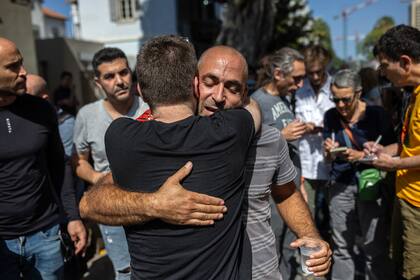 Avichai Broduch, cuya esposa y tres hijos fueron secuestrados, es abrazado en una manifestación que pide a Hamas que libere a los rehenes, en Tel Aviv, Israel. (Tamir Kalifa/The New York Times)