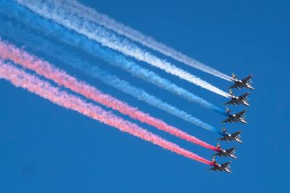 Aviones de asalto Sukhoi Su-25 rusos liberan humo con los colores de la bandera rusa mientras vuelan sobre el centro de San Petersburgo durante el desfile del Día de la Marina el 26 de julio de 2020