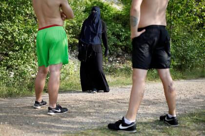 Ayah, de 37 años, portadora del niqab, habla con nadadores durante una visita a Karlstrup Kalkgrav, un lago cerca de Karlstrup, ubicado en las afueras de Copenhague.