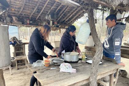 Ayelén y sus papás cocinan pizzas para comer al mediodía; ella es la encargada de cortar y poner el queso