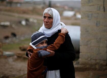 Ayman, junto a su abuela tras regresar con su familia, en Irak