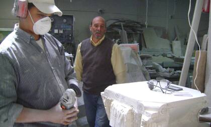 Baccarelli y un oficial confeccionan una pila bautismal en mármol travertino