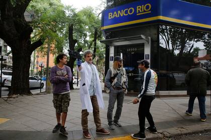 Rafael Ferro, con guardapolvo de médico, junto a Peretti