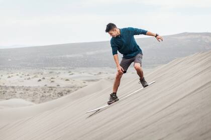 Bajando la duna en tabla de sandboard.