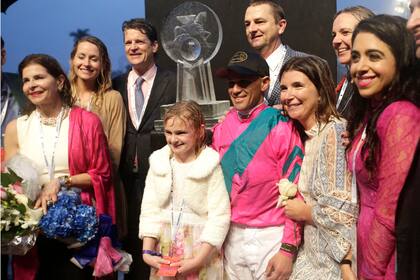 Bajo la lluvia, parte del equipo ganador de la Pegasus World Cup, con Stella McCarthy en el centro