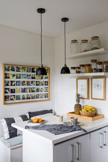 Banco con tapa que llama el “guarda todo” y mesada haciendo juego realizadas a medida. Un cuadro con fotos y dos obras de su íntima amiga Victoria Yost, artista plástica.