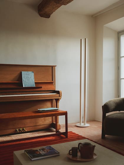 Banco de abedul '01' de Frama en lugar de un taburete de piano tradicional. Lámpara de pie 'L1', diseñada por Pierric de Coster para Valerie Objects.
