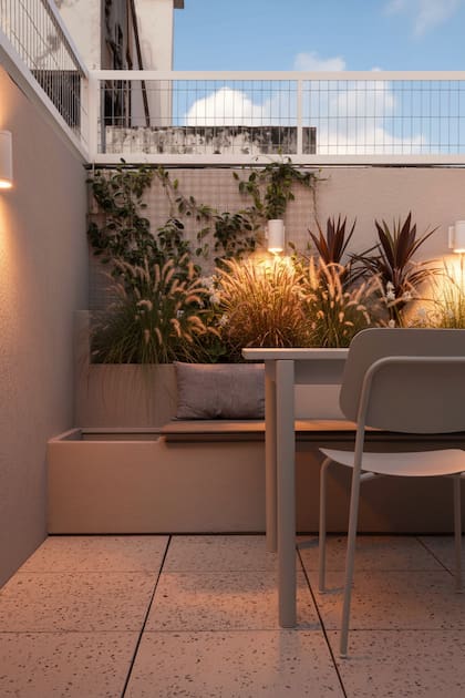 Banco fijo (Green Deco), muebles sólidos pero livianos, buena iluminación, un cantero con nativas y alambre para que trepe la enredadera. Una terraza bien pensada.