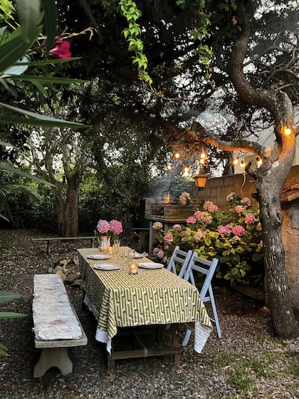 Bancos de piedra, una mesa rústica y hortensias en flor. La parrilla es el lugar ideal para cerrar los días de playa.