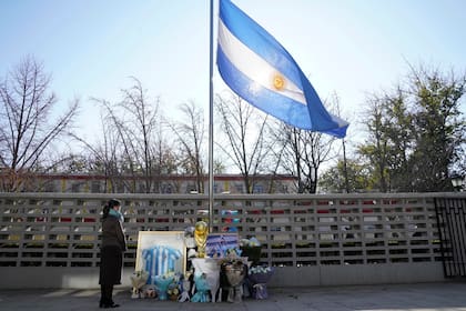 Bandera a media asta y altar improvisado en la puerta de la embajad Argentina en la capital de China