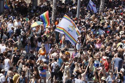 Banderas de arco iris ondeaban en la playa mientras la gente inundaba las calles de Tel Aviv el viernes por el desfile anual de Orgullo Gay de la ciudad