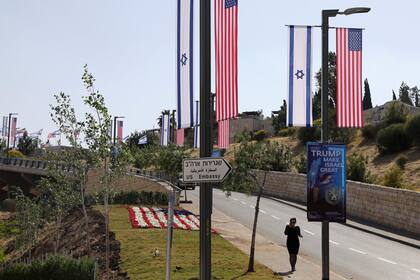 Banderas de EE.UU. e Israel y carteles que indican la nueva ubicación de la embajada