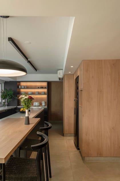 Banquetas altas en estructura de madera con lustre negro y kraft negro (Marini), lámpara colgante y apliques (Paraná 201).