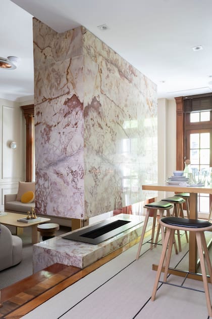 Banquetas de madera con asiento tapizado y barra (todo de Mesopotamia) con tapa de Neolith (Polimar). Alfombra (Rugit).