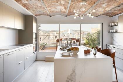 Banquetas 'Koki' (Desalto), lámpara decorativa 'Birdie', de Ingo Maurer. Mesada en Corian (Inalco) con grifería en acero inoxidable (Blanco).