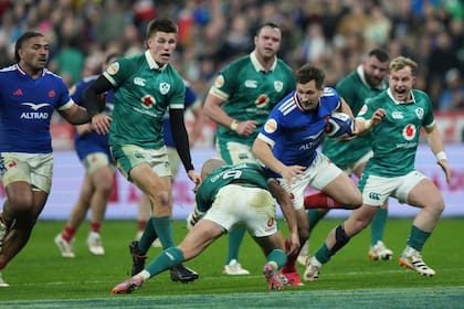 Baptiste Serin intenta escapar al tackle de Jamison Gibson-Park (AP Photo/Thibault Camus)