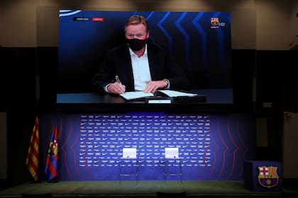 El entrenador del Barcelona, Ronald Koeman, firma su contrato. Suárez dice que todavía no se comunicaron.