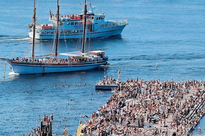 Barcos pasan frente a la concurrida zona de baño en Sorenga, Oslo, en la piscina interior del puerto de la capital noruega 