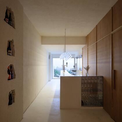 Barra de material y tapa de microcemento blanco; el cristalero es de chapa galvanizada. Mueble y acceso a los toilettes de melamina (todo diseñado y realizado por Wollstudio). Revestimiento de pared acrílico (Quimtex Vallarta).