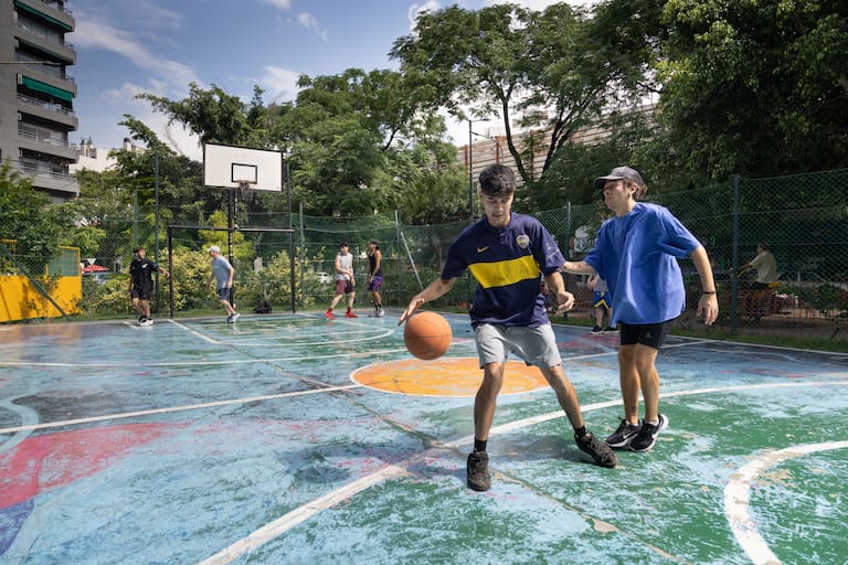 A la derecha un mural del edificio IMPA y a la izquierda chicos jugando en la plaza Almagro (Estralla Herrera)
