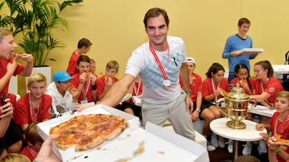Basilea, Suiza - El suizo Roger Federer celebra con los niños alcanzapelotas, comiendo pizza