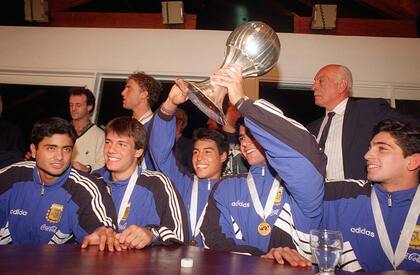 Bayon, Garrone, Chaparro, Biagini y Coyette, con la Copa obtenida en Qatar en 1995; detrás, pasa caminando Carlos Arangio