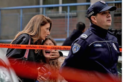 Una madre contiene a su hija tras el tiroteo en la escuela de Belgrado (Oliver Bunic / AFP)