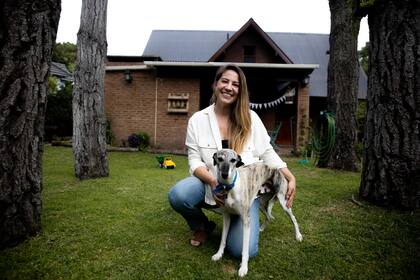 Bella y uno de sus perros en el patio de su casa