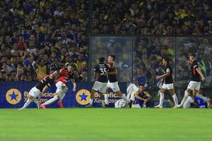 Beltrán celebra su gol agónico sobre Boca; el Pulga lo mira de lejos, con una sonrisa pícara