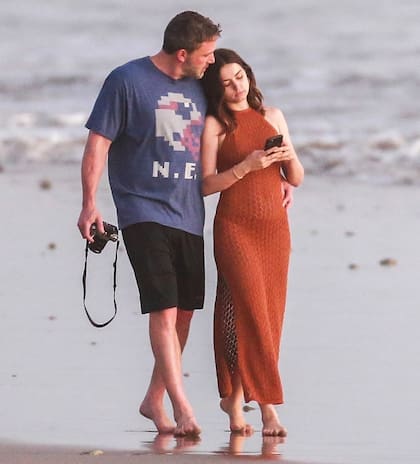 Ben Affleck y Ana de Armas, compañeros en la pantalla y pareja en la vida real, caminando juntos abrazados en la playa