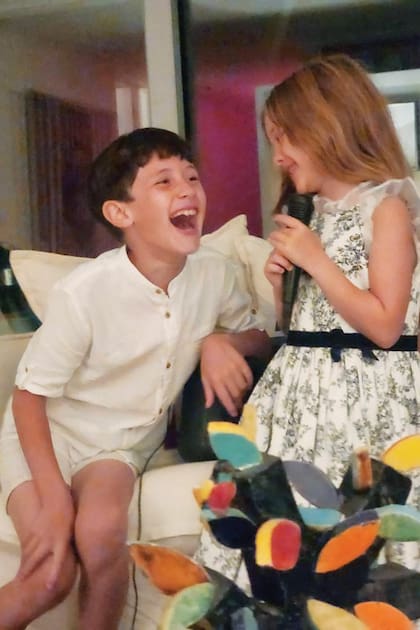 Benicio y Magnolia se divierten mientras juegan con un micrófono.