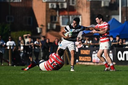 Benjamín Belaga, del CASI, es tackleado por Santiago González Iglesias (12) y Cruz González Bibolini