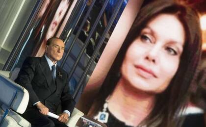 Berlusconi, ayer en un estudio de la RAI, con su ex mujer de fondo