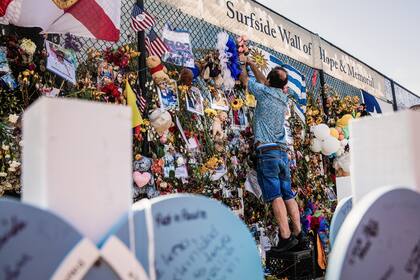 Bernardo Camou coloca un rosario en una cerca conmemorativa para su hermana y su esposo, quienes se encontraban entre las 98 personas que murieron.