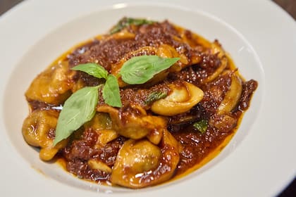 Besitos de Julia: raviolones rellenos de rúcula, ricota, almendras y queso de cabra, salteados en tomates disecados, miel, almendras y oliva