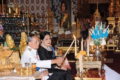 Bhumibol Adulyadej y la reina Sirikit encienden velas en la cremación real de la difunta hermana del rey, la princesa Galyani Vadhana