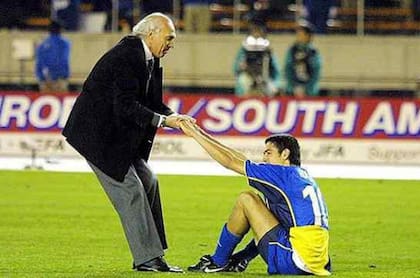 Bianchi ayuda a Riquelme a ponerse de pie, tras la derrota de Boca ante Bayern Munich en 2001