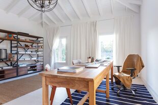 Biblioteca de hierro y madera. Escritorio hecho con maderas de demolición y sillas de los años 50 recuperadas. El techo de madera se pintó de blanco para ganar profundidad y reflejar la luz natural.