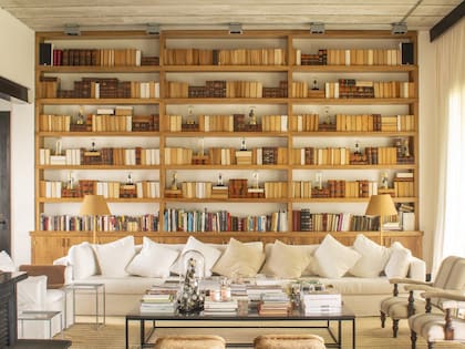 Biblioteca de petiribí y barra en cerejeira negra (Oda 9) iluminada con colgantes de Fábrica de Luz.