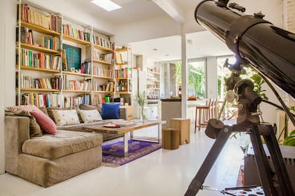 Biblioteca (diseño Estudio YME) en caño pintado blanco y guatambú macizo. En el centro, obra de Manuel Espinosa. Los almohadones sobre el sillón heredado son de Compañía de Blockprint.