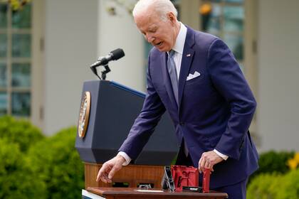 Biden muestra piezas de una pistola calibre 9mm mientras habla en los jardines de la Casa Blanca en Washington, el 11 de abril pasado