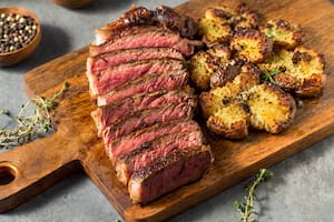 Bife de chorizo con papas aplastadas