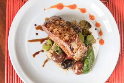 Bife de llama con timbal de quinoa y vegentales salteados.