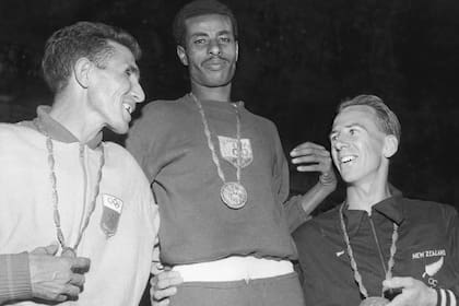 Bikila en el podio de la maratón de Roma 1960, junto al marroquí Rhadi Ben Abdesselam (plata) y el neocelandés Barry Magee.