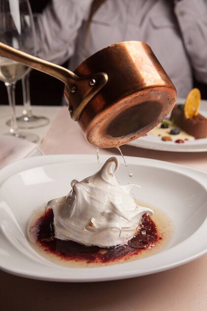 Biscuit húmedo con helado de dulce de leche y merengue italiano flameado con coulis de frutos rojos y licor de naranja.