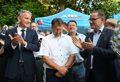 Bjorn Hocke, izquierda, Robert Sesselmann, centro, Stephan Brandner, tercero de izquierda a derecha, y Tino Chrupalla, miembros del partido Alternativa para Alemania, acuden a un festejo del partido en Sonneberg, Alemania, el domingo 25 de junio de 2023. (Martin Schutt/dpa vía AP)